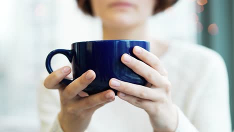 woman holding a blue mug