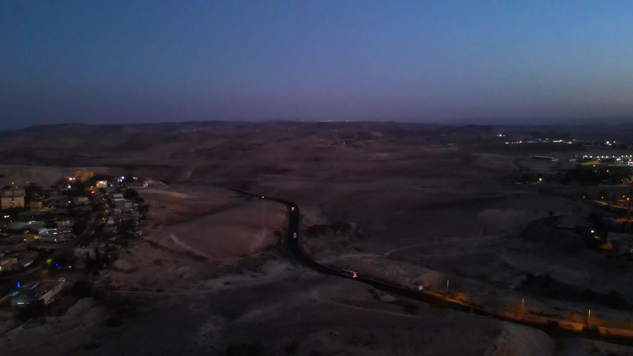 città nel deserto al tramonto, una strada principale porta alla città dalla vastità del deserto