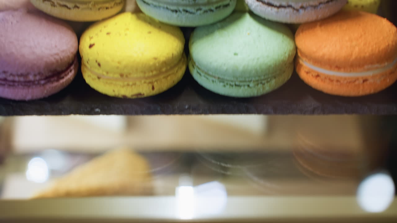 Creamy cheesecake slices with rich chocolate topping and sprinkled nuts displayed on wooden tray under dessert counter, capturing varied angles and lighting reflections in warm bakery setting