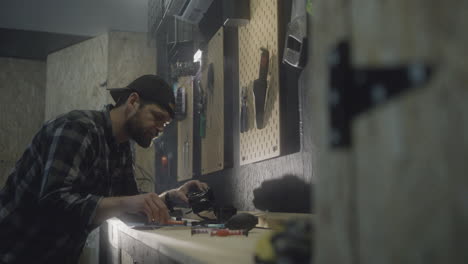 Man-disassembly-camera-body-and-sensor,-holding-tools-in-Indoor-workspace,-Portrait-shot