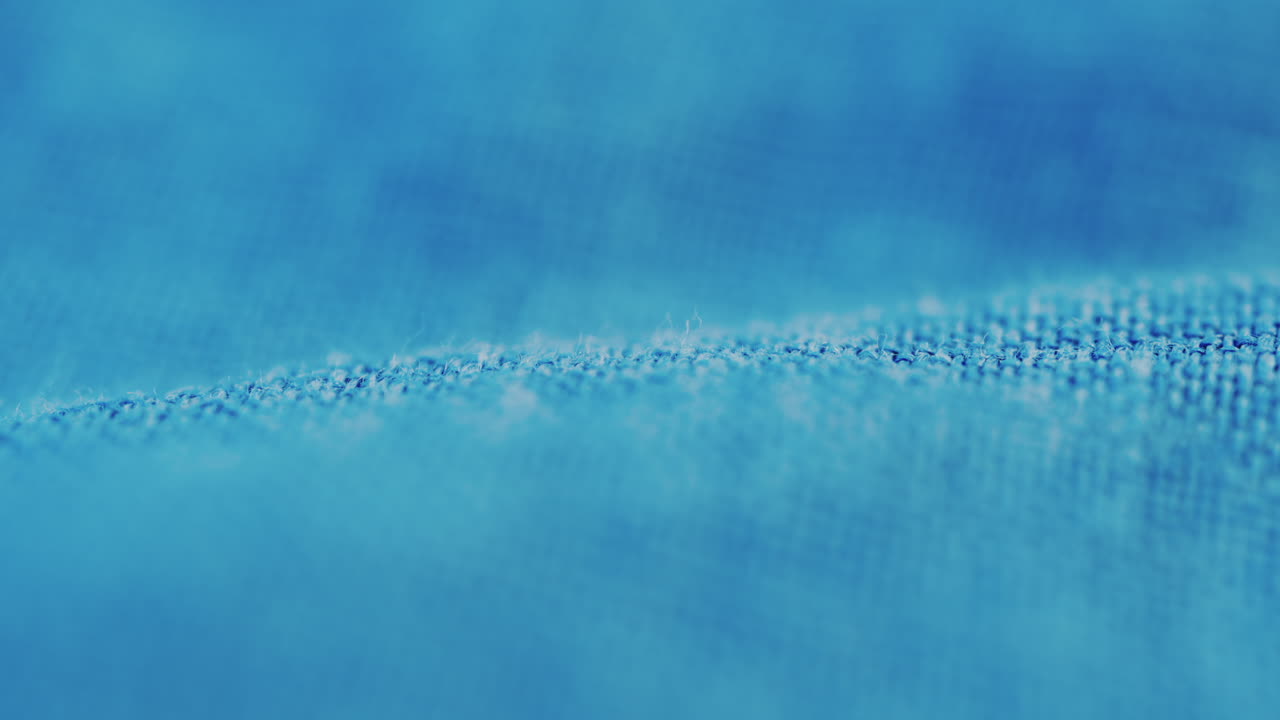 Close up of blue denim fabric texture showing fine threads and detailed textile pattern