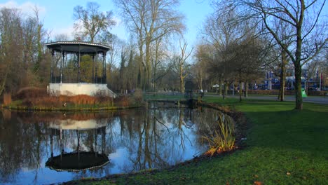 Vondelpark-in-Amsterdam,-with-famous-hut-on-a-small-island-surrounded-by-a-pond-during-fall