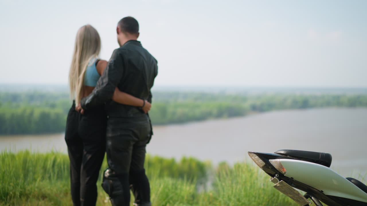 언덕 위의 오토바이 근처에 사랑하는 여자친구와 함께 운전자