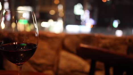 close-up of wine glass against blurred cityscape