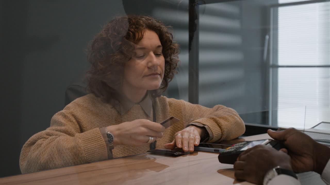 Woman making a payment at a secure counter