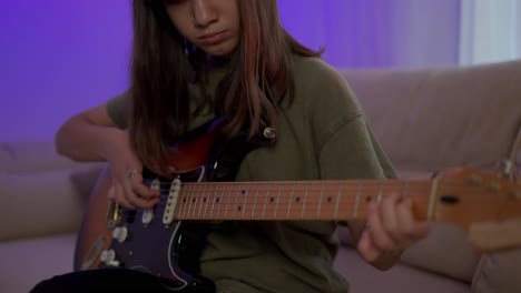 teen girl learns to play the guitar, closeup