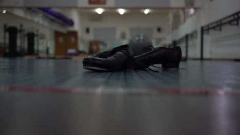 in the empty room, the women's tap shoes fall to the floor