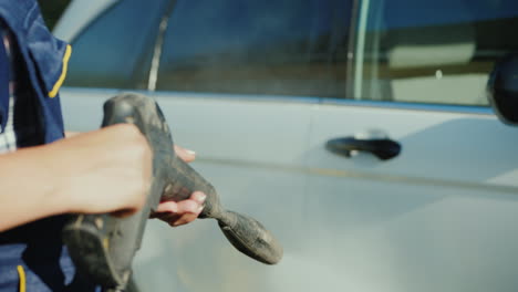 woman's hands hold the nozzle of a pressure washer washes white