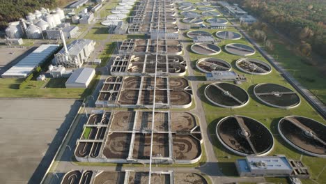 aerial establishing shot of a huge biological wastewater treatment plant on evening flying forward