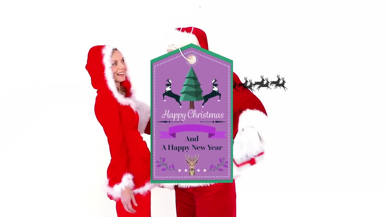 Animation of gift tag with season's greetings over man and woman in santa claus costume
