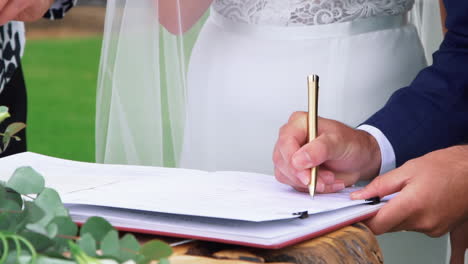 groom signing the official wedding certificate - close up