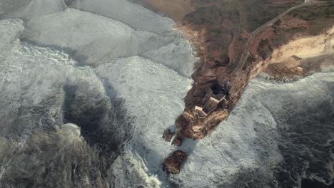 acantilado de nazare y enormes olas espumosas, toma aérea giratoria