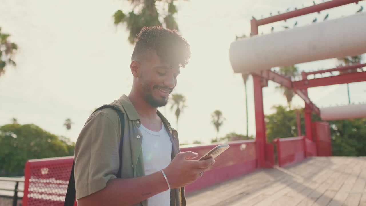 Man using phone on bridge