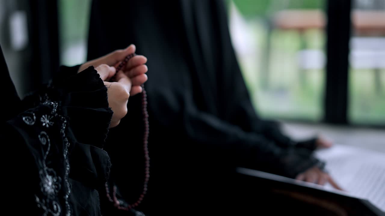 쿠란을 읽는 동안 젊은 무슬림 여성의 손을 가까이 들고