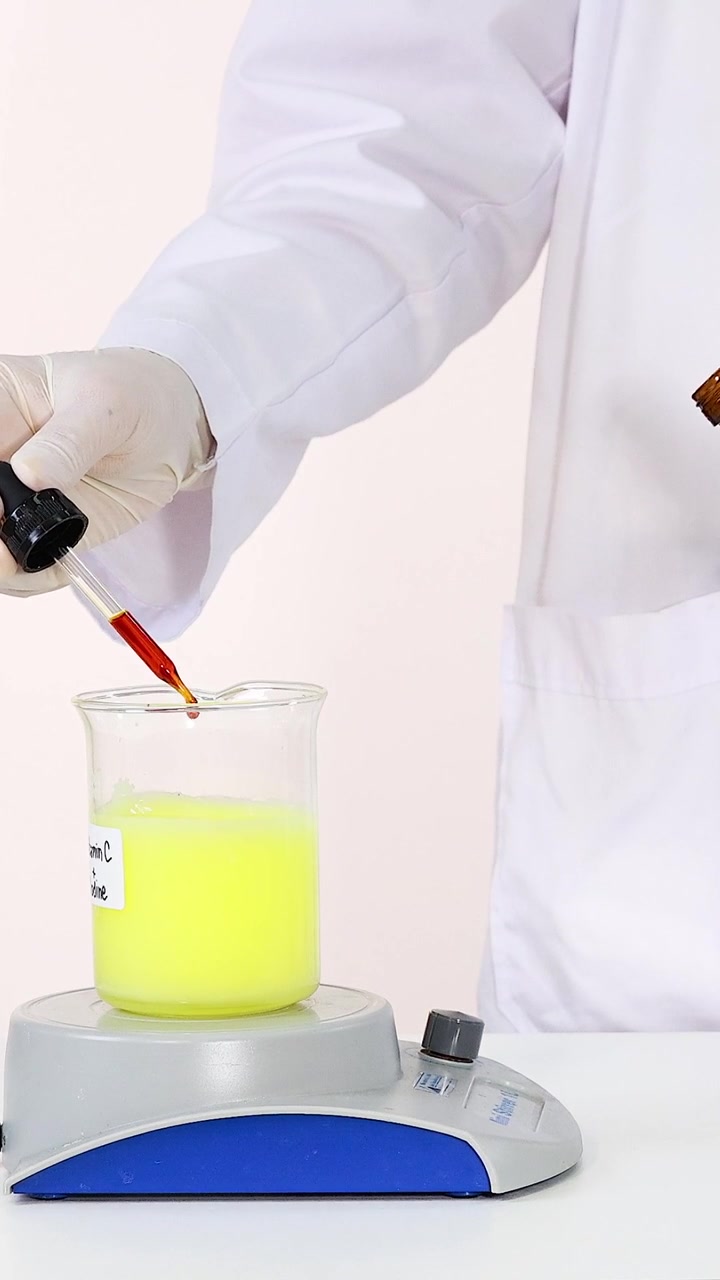 Scienziato che aggiunge sostanze liquide per eseguire la reazione chimica dell'orologio a iodio