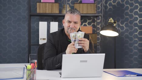 Businessman-counting-money-looking-at-camera.