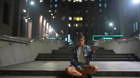 una mujer joven sentada en las escaleras por la noche