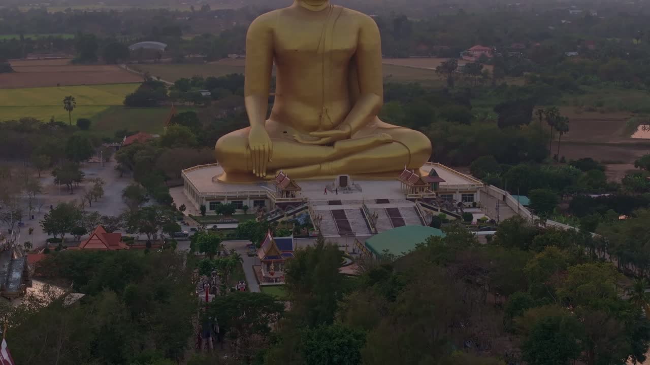Gigante statua dorata di Buddha che si erge sopra i campi ad Ang Thong, Thailandia