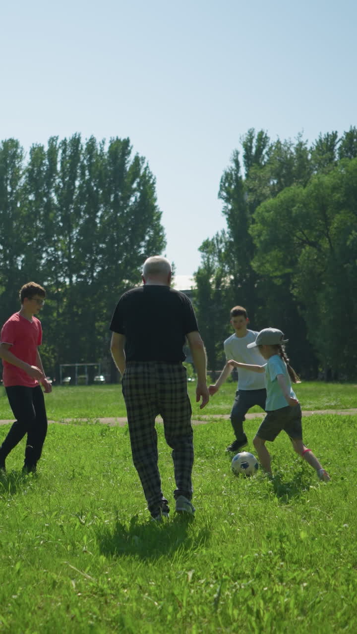 hermanos y su abuelo disfrutan de un día soleado jugando al fútbol juntos en un campo verde exuberante