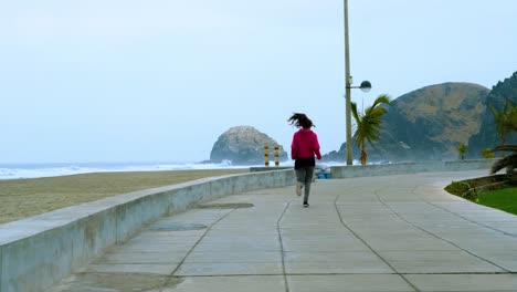 fitness joven morena corriendo y trotando sola junto al mar
