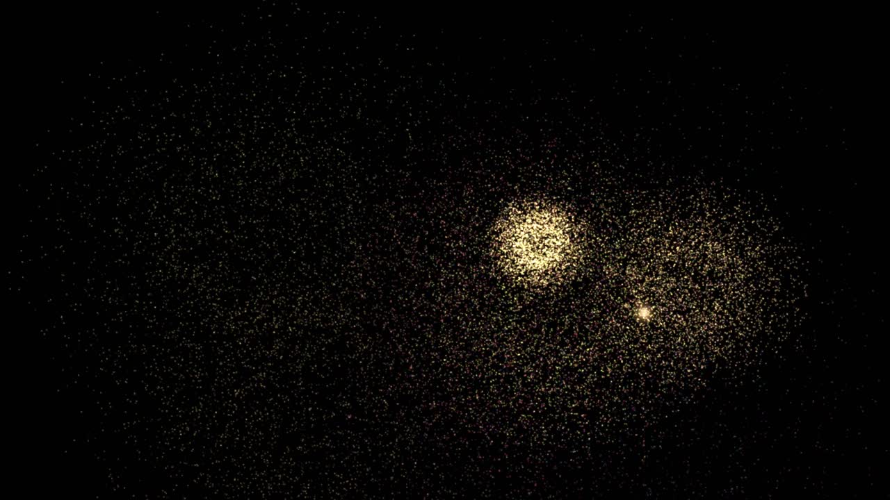 Esplosioni di vibranti particelle multicolore simulano fuochi d'artificio che esplodono su uno sfondo nero con illuminazione soffusa