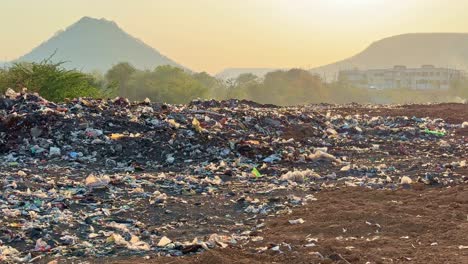 static shot of a land filled with wasted plastic bag creating microplastic pollution and burning the garbage creating the air pollution