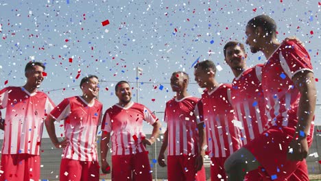 colorful confetti falling against team of male soccer players smiling together on grass field