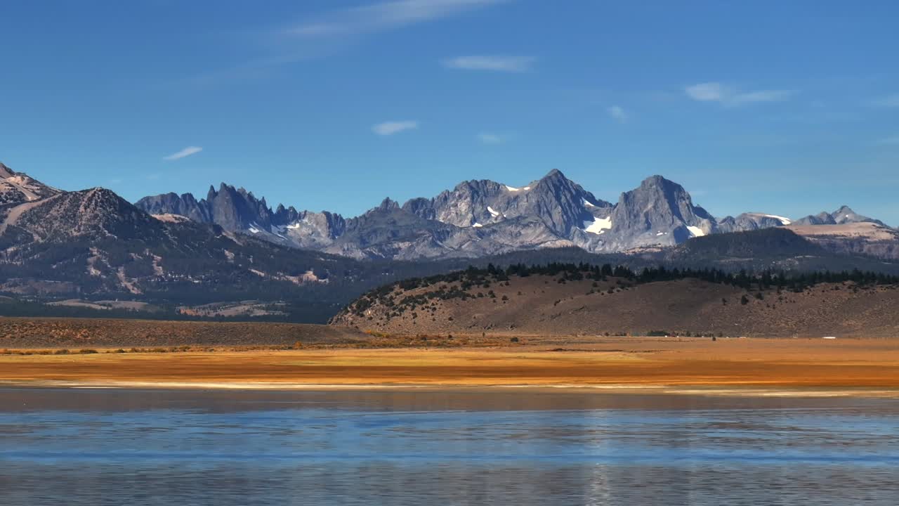 Lake Crowley Minarets Vista Mammoth Lakes California aerial drone summer fall autumn sunny blue sky clouds snow Bishop Sierra Nevada Mountains Hilltop Hotsprings parallax right motion
