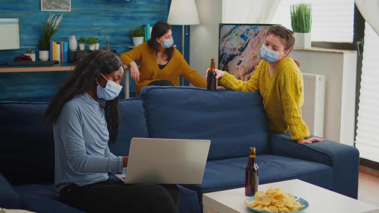 Happy african woman showing video on laptop to friend