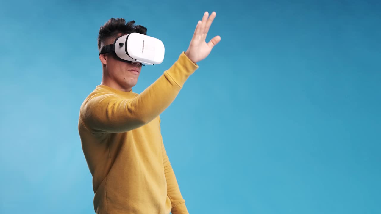 Man touching something in the air while experiencing virtual reality with a VR headset.