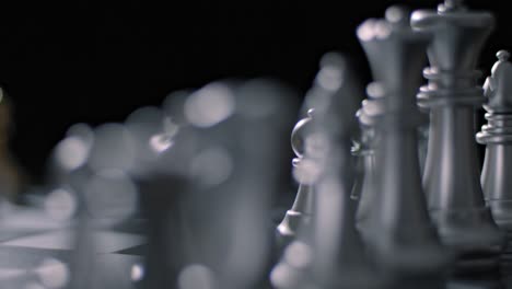 Cinematic-detail-shot-of-silver-chess-pieces-set-up-on-chess-board