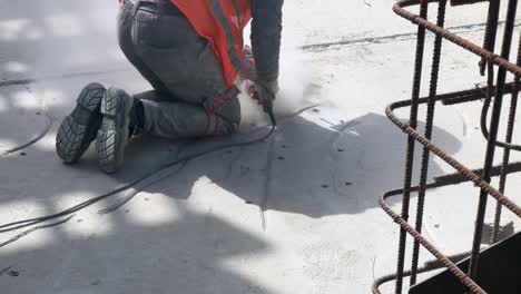 construction worker grinds a concrete surface with angle grinder