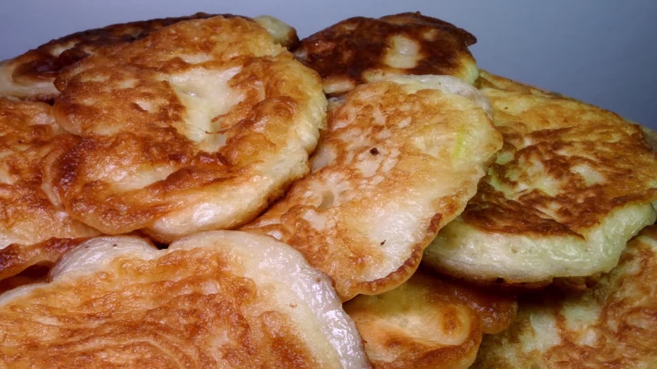 una pila de panqueques dulces fritos hechos en casa girando en el plato.