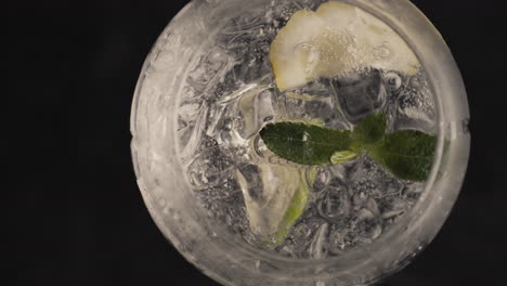 bubbled lemon ice mint cocktail spinning glass closeup. summer drinks concept