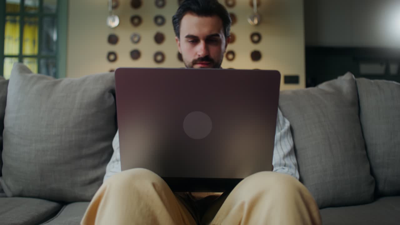 hombre trabajando en una computadora portátil en casa
