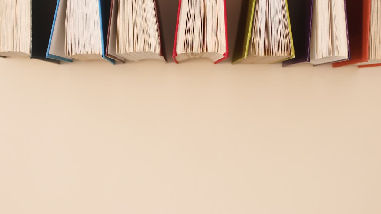 Hardcover vintage retro books ordering on beige background. Stop motion flat lay