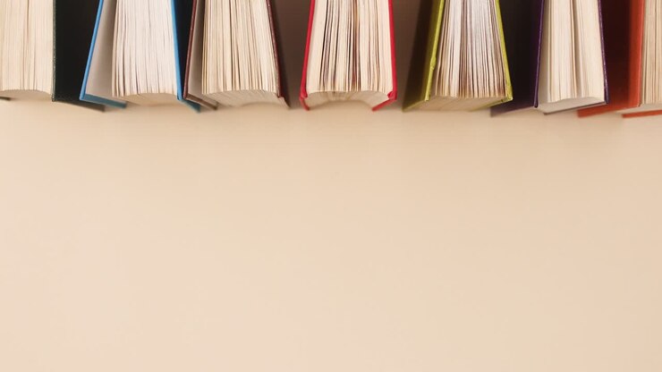 Libri vintage retrò con copertina rigida disposti su sfondo beige. Flat lay in stop motion