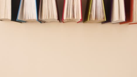 libros vintage de tapa dura que se ordenan sobre un fondo beige.