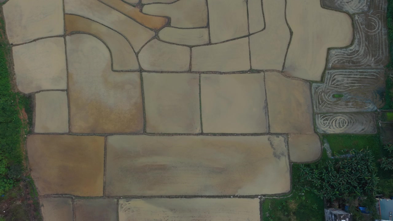 Vista aérea de una granja. La vista superior muestra tierras de cultivo rurales después de la recolección de los cultivos. Un vehículo aéreo no tripulado captura un extenso paisaje rural tras la finalización de la temporada de cosecha.