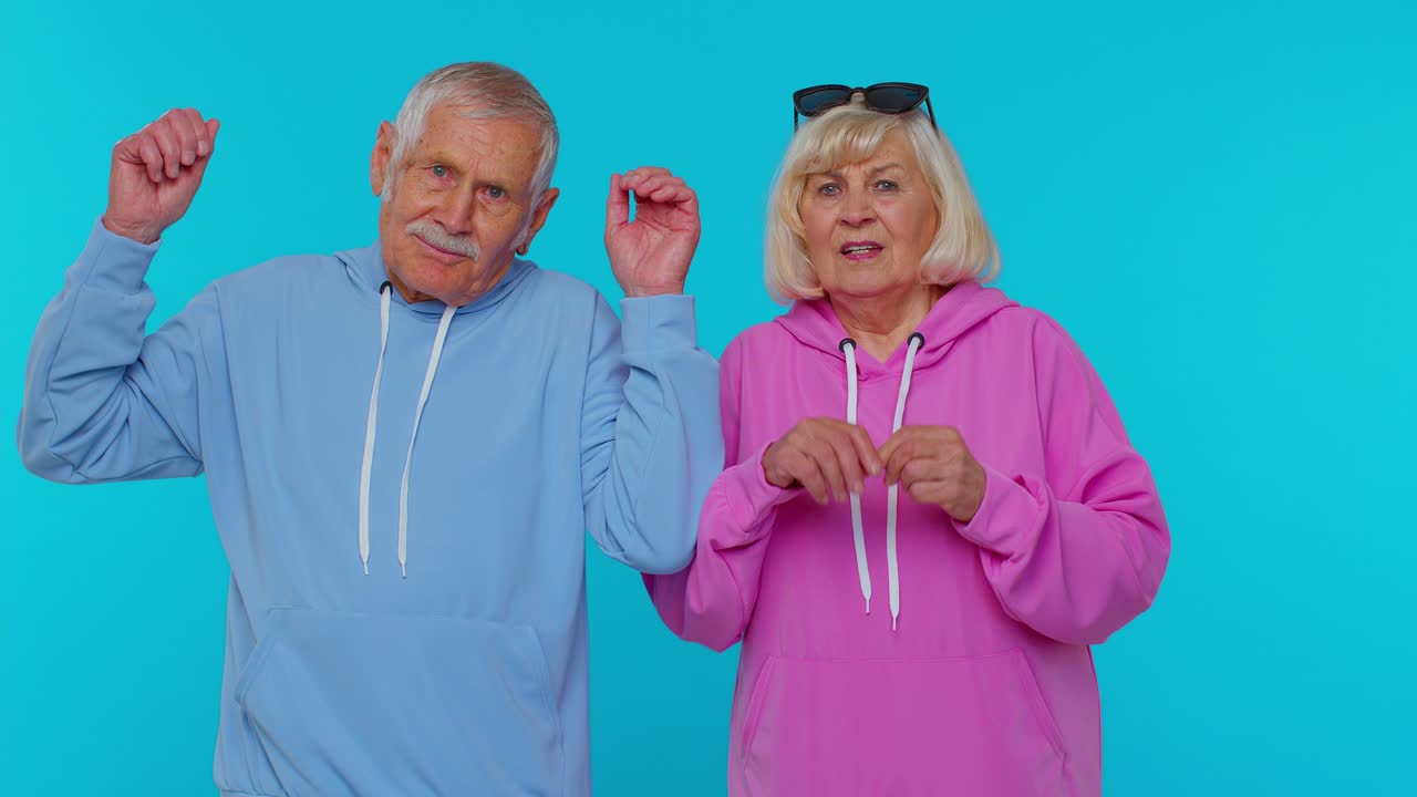 Happy Elderly Couple in Hoodies Posing Together
