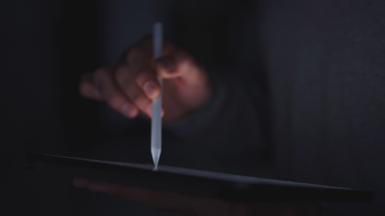 Close Up Of Woman Drawing On Digital Tablet Using Stylus Pen At Night