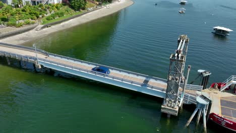 Toma-De-Drone-De-Un-Pequeño-Automóvil-Azul-Que-Sale-Del-Ferry-Privado-De-Herron-Island