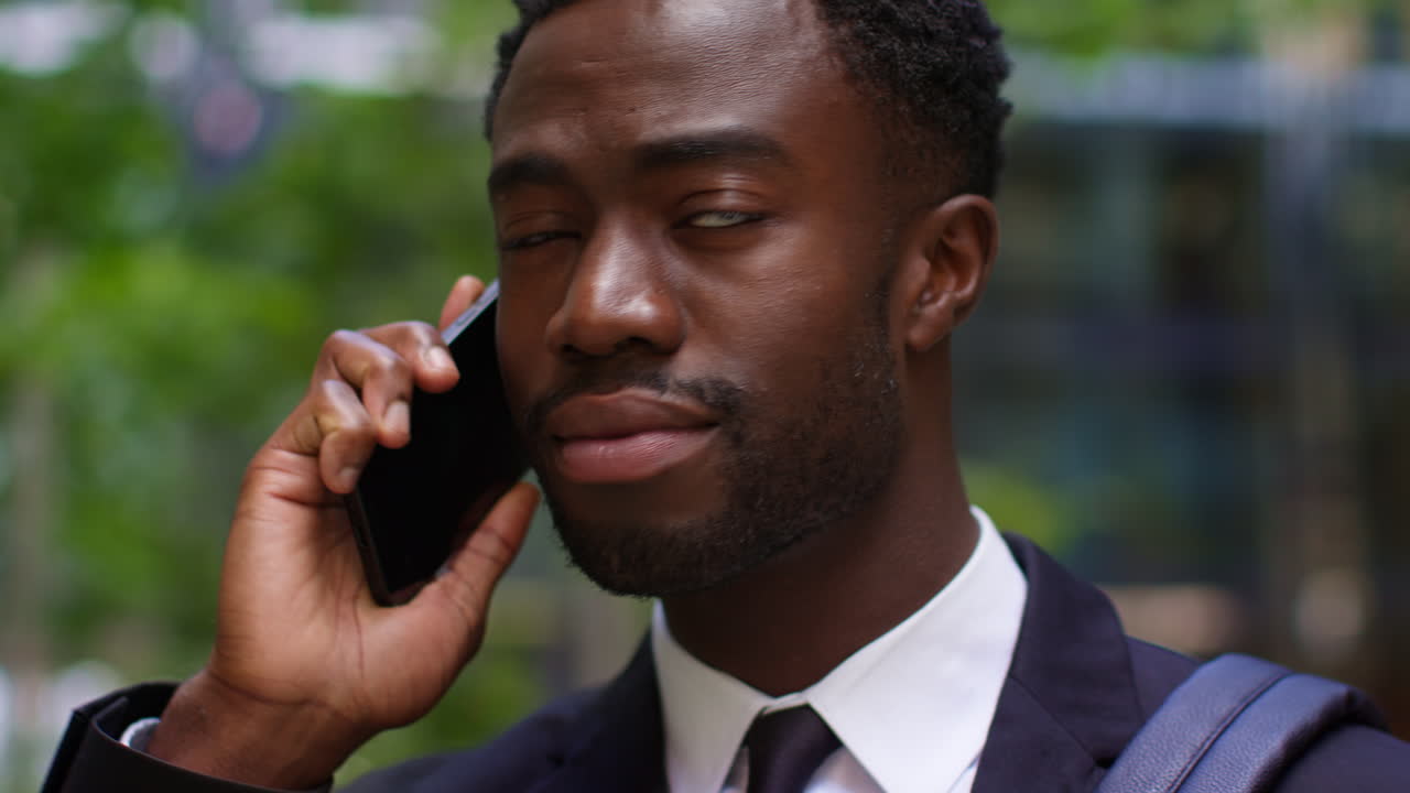 Close Up Of Young Businessman Wearing Suit Taking Call On Mobile Phone Standing Outside Offices In The Financial District Of The City Of London UK
