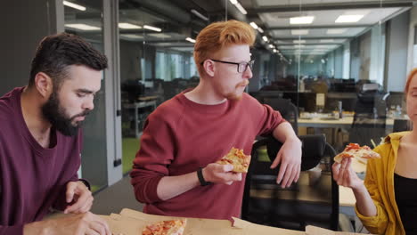 office workers eating pizza indoors