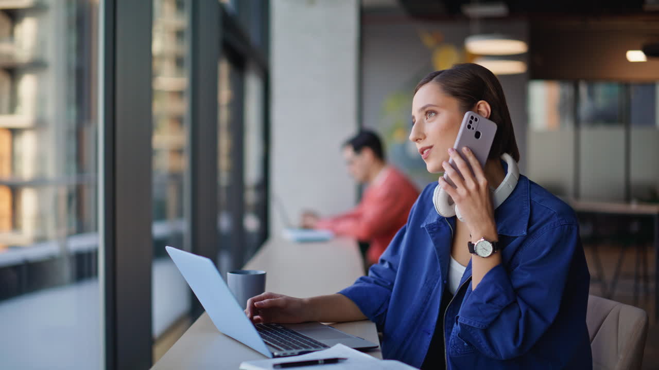 Primo piano di un manager di successo che parla al telefono e prende appunti su un taccuino in un bar