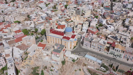 aerial: slow panning drone shot of saint nicholas church in ermoupoli of syros island, greece