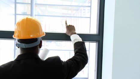 afroamerican architect studying a building through a window