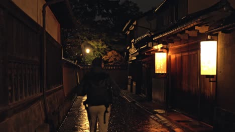 a man strolls through the historic streets of kanazawa at night, surrounded by traditional japanese architecture and the soft glow of lanterns.