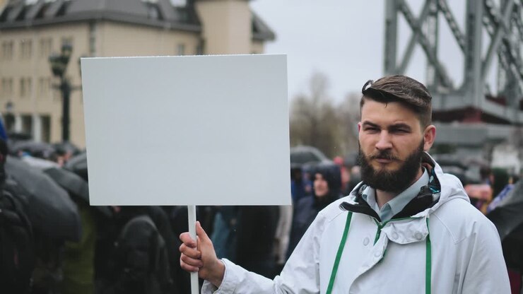 Sad man on funeral holds blank advertising copyspace card board banner for text.