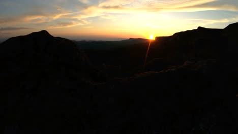 mountain sunset over the peak rock. dark key sunset light in the mountains parallax rocks rock grass